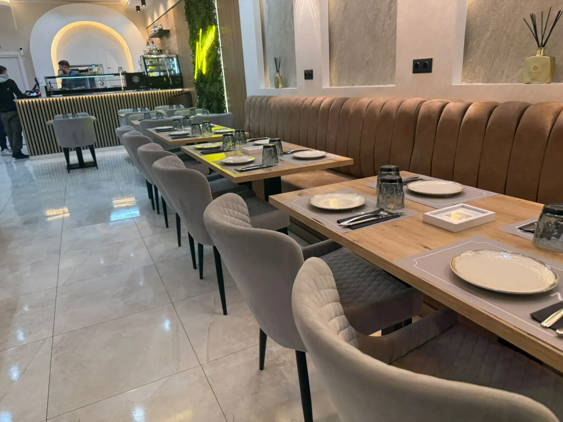 Sala de Nayam con mesas de madera y butacas de terciopelo